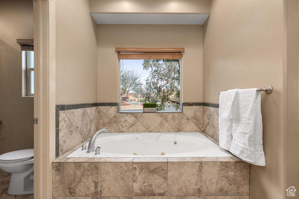 Bathroom featuring toilet and a whirlpool tub