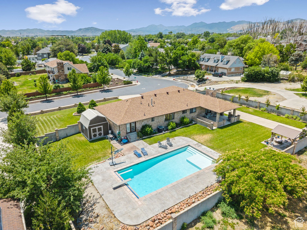 Aerial view of property and surrounding area featuring a pool area and a mountain backdrop