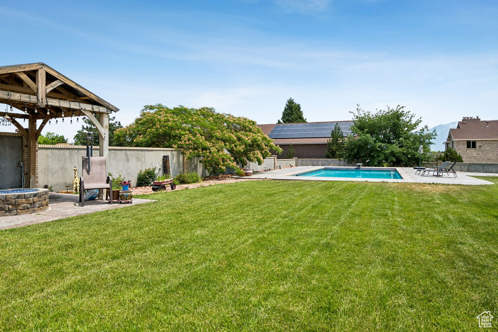 Fenced backyard with a gazebo, a patio area, and an outdoor fire pit