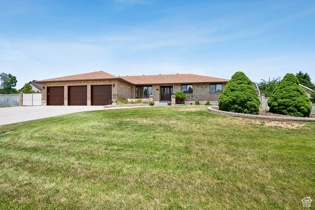 Single story home featuring an attached garage, concrete driveway, and brick siding