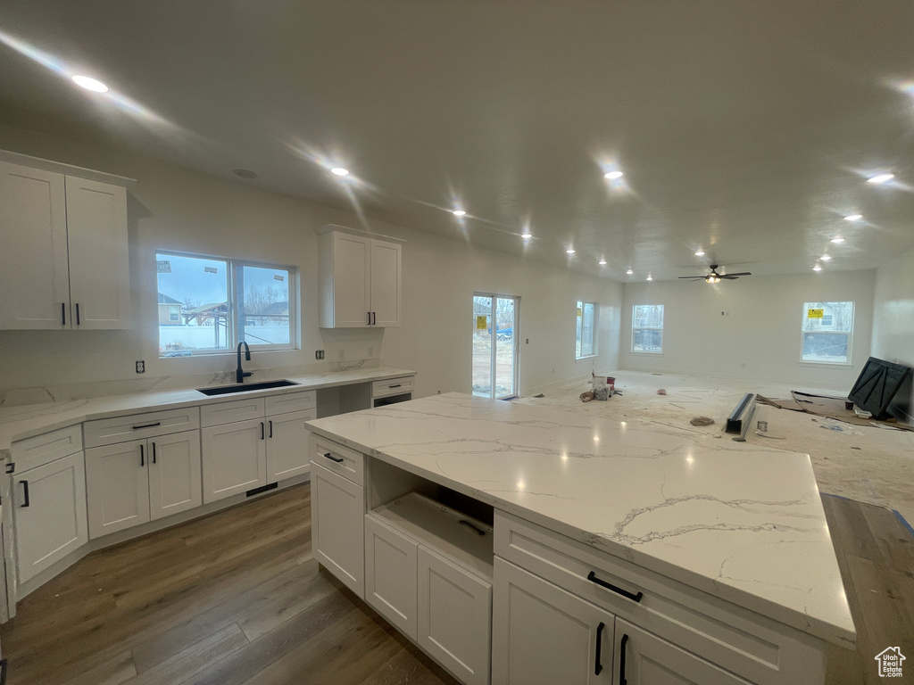 Kitchen with dark wood finished floors, white cabinetry, a ceiling fan, and a sink