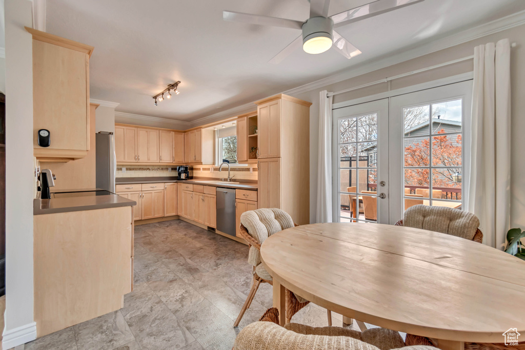 Kitchen with plenty of natural light, appliances with stainless steel finishes, ornamental molding, and light brown cabinets