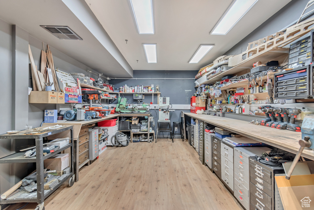 Miscellaneous room with visible vents, a workshop area, and wood finished floors
