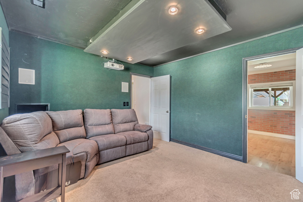 Carpeted living area featuring brick wall
