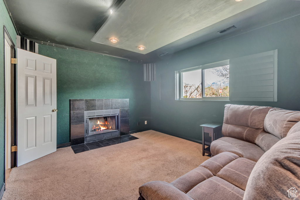 Carpeted living area with visible vents and a fireplace