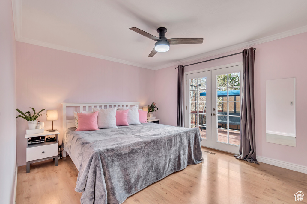 Bedroom featuring access to exterior, french doors, crown molding, and light wood-style floors