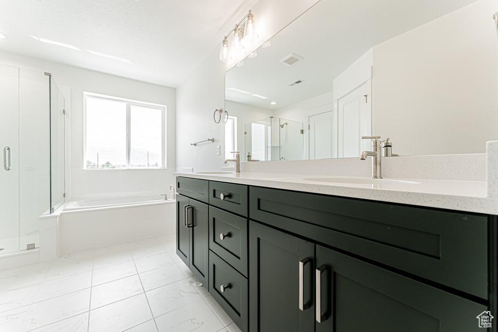 Bathroom with a shower stall, a bath, and double vanity
