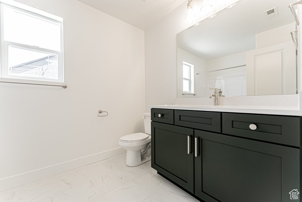 Full bath with marble finish floors, vanity, and a shower