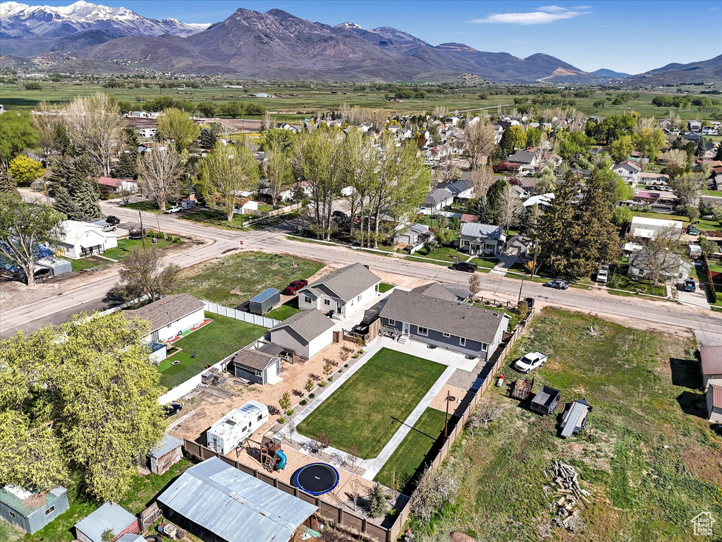 Aerial view of property and surrounding area with a mountain backdrop and nearby suburban area