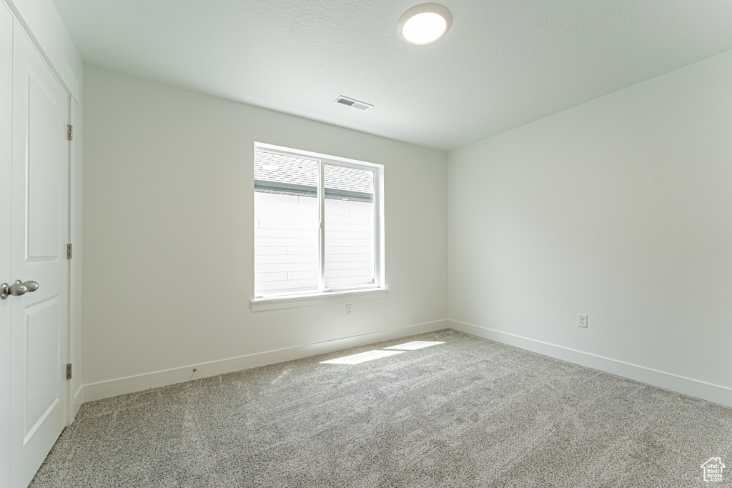 Carpeted empty room with baseboards