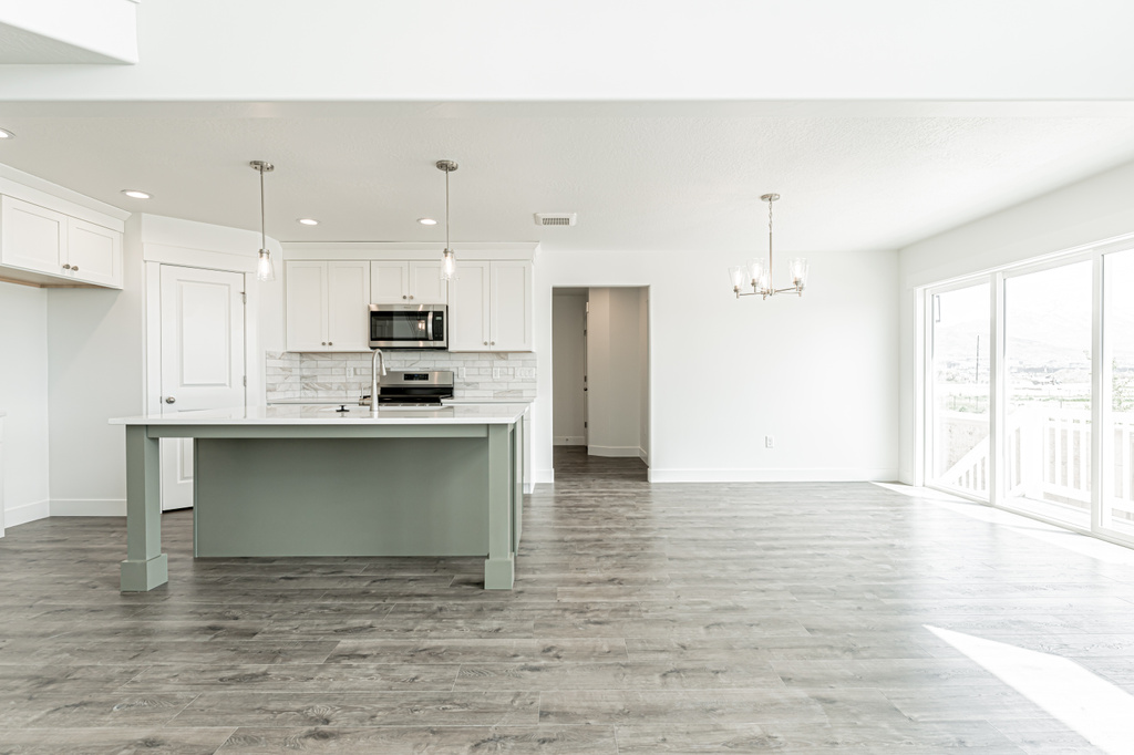 Kitchen featuring stainless steel appliances, a chandelier, recessed lighting, backsplash, and light countertops