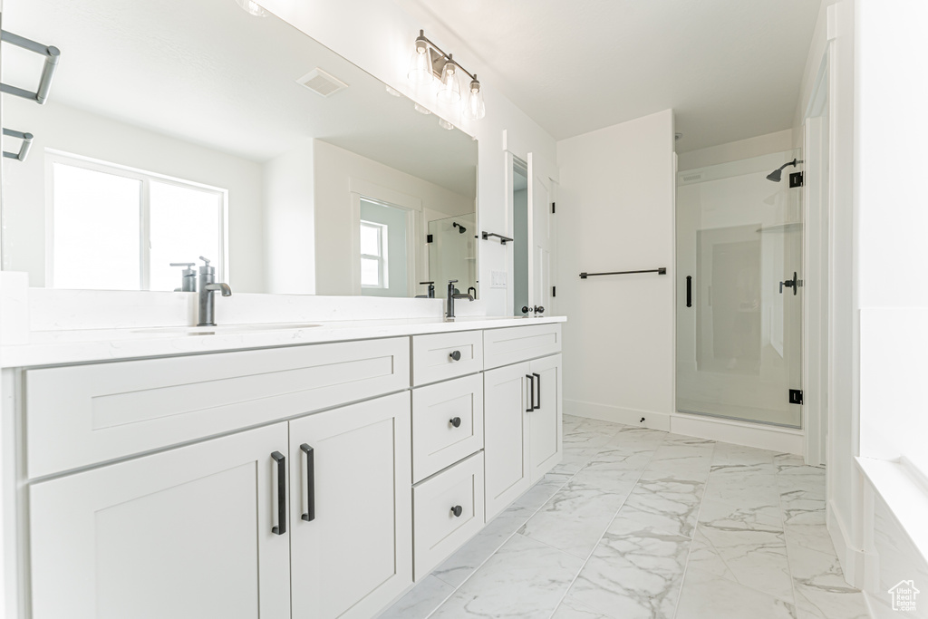 Full bath with a shower stall, marble look tile flooring, double vanity, and a bathtub
