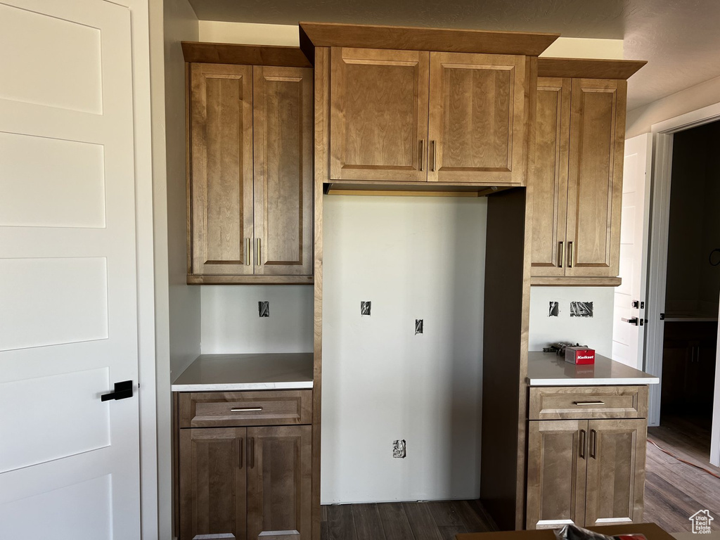 Kitchen featuring dark wood finished floors, light countertops, and brown cabinets