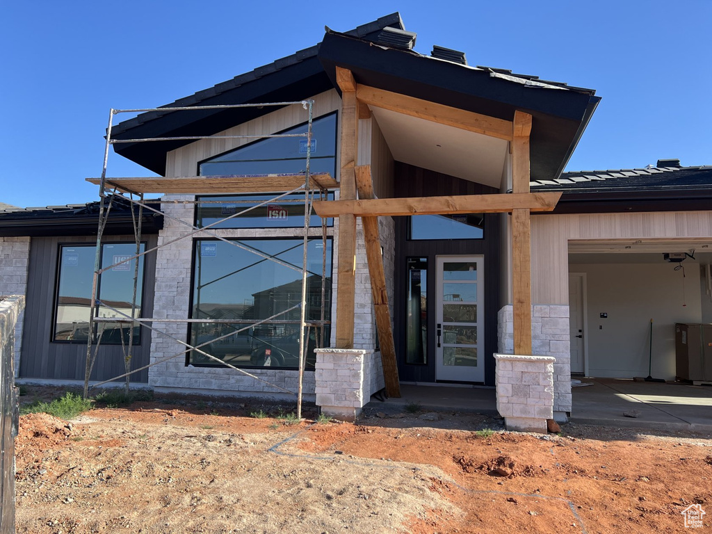 Doorway to property featuring driveway and stone siding