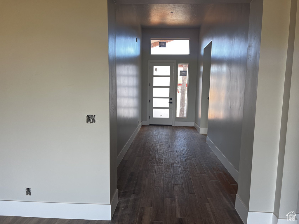 Doorway featuring dark wood-style flooring and baseboards