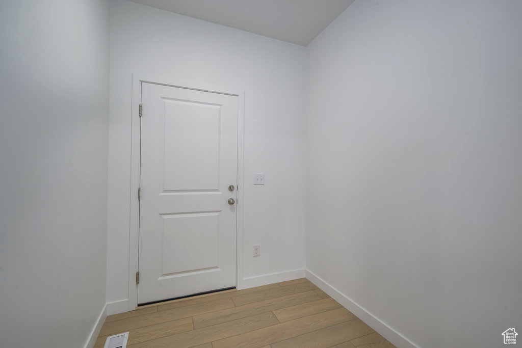 Doorway to outside with visible vents, baseboards, and light wood finished floors