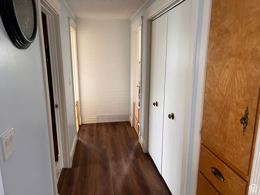 Hallway featuring dark wood-style flooring and baseboards