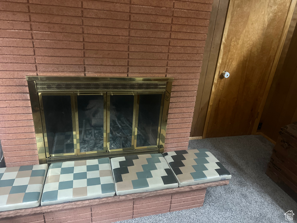 Detailed view of a brick fireplace and tile patterned floors
