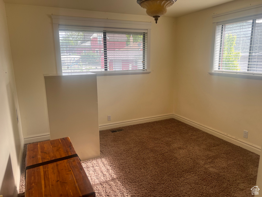 Carpeted empty room featuring baseboards