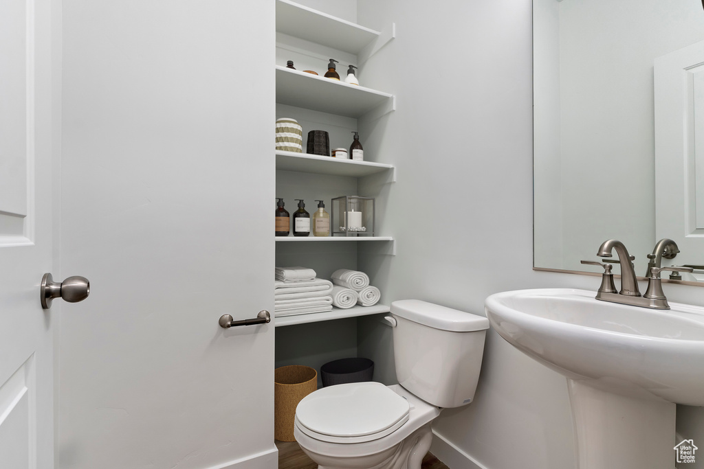 Half bathroom with toilet and baseboards