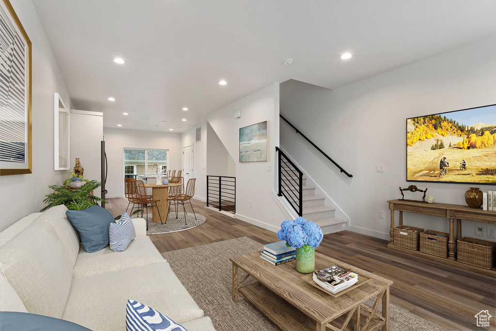Living room featuring visible vents, recessed lighting, stairway, and wood finished floors