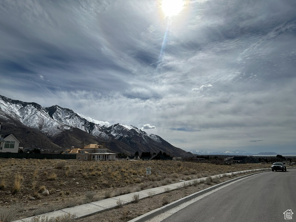 View of road with curbs, a mountain view, and sidewalks