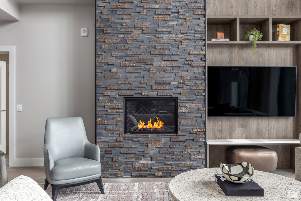 Living room with a glass covered fireplace and wood finished floors