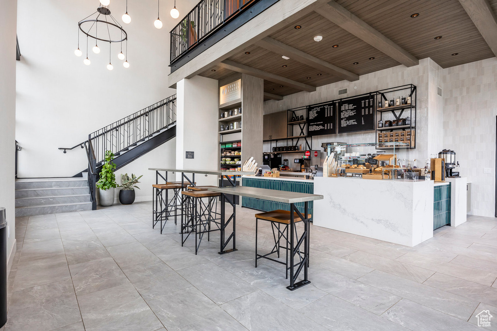 Kitchen with open shelves, a high ceiling, wood ceiling, and beamed ceiling