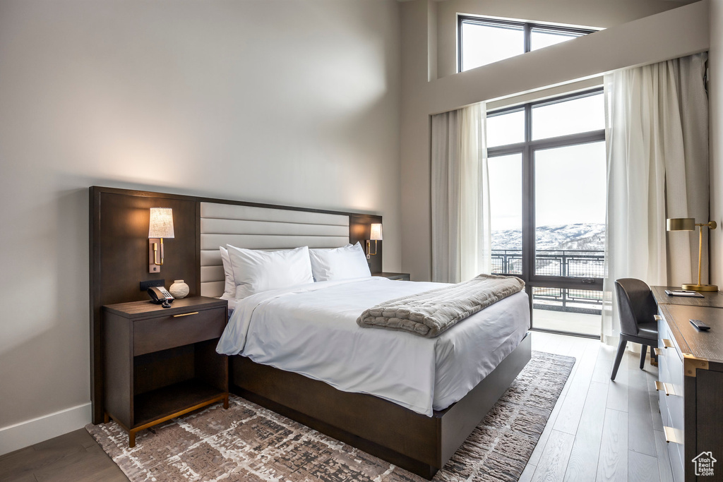 Bedroom with multiple windows, baseboards, and wood finished floors