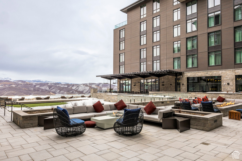 View of patio / terrace featuring a mountain view and an outdoor living space with a fire pit
