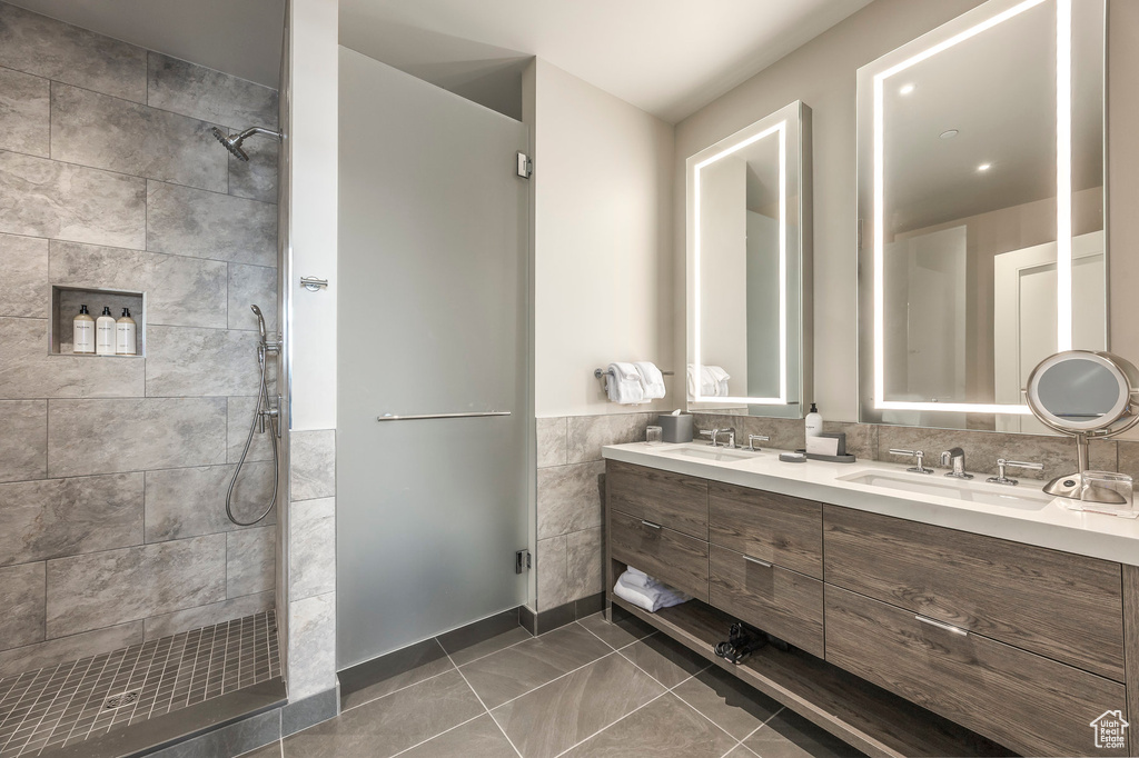 Bathroom with double vanity, walk in shower, and a sink