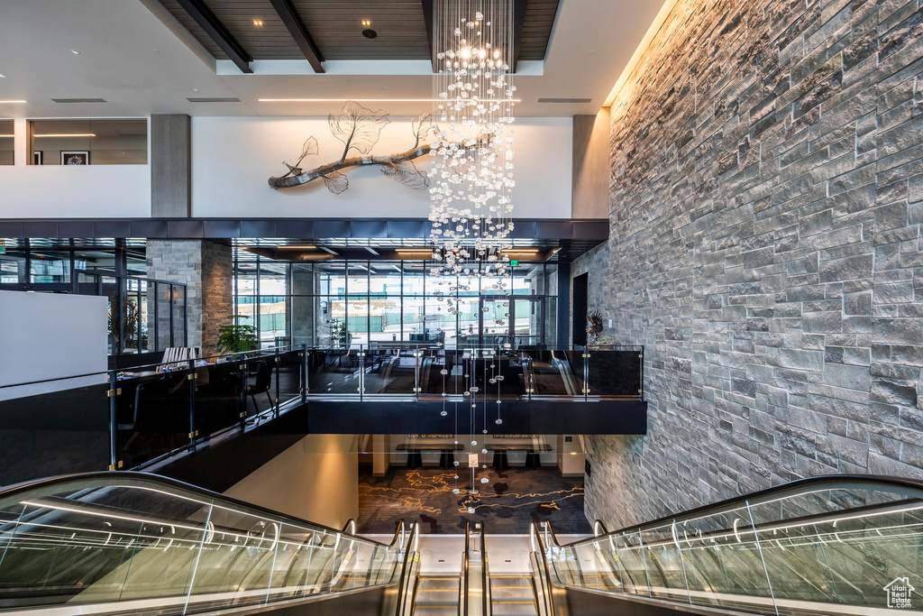 Interior space with beam ceiling, a high ceiling, and a chandelier