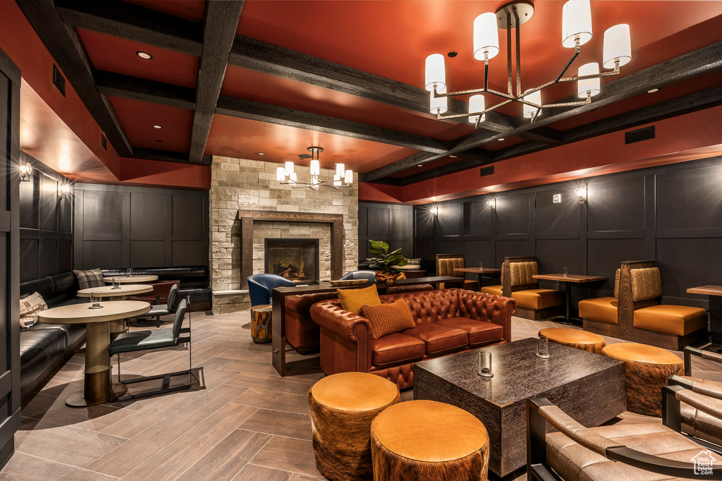Home theater room featuring a decorative wall, beamed ceiling, coffered ceiling, and visible vents