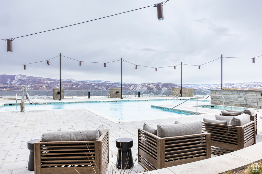 Pool with a mountain view, outdoor lounge area, and a patio