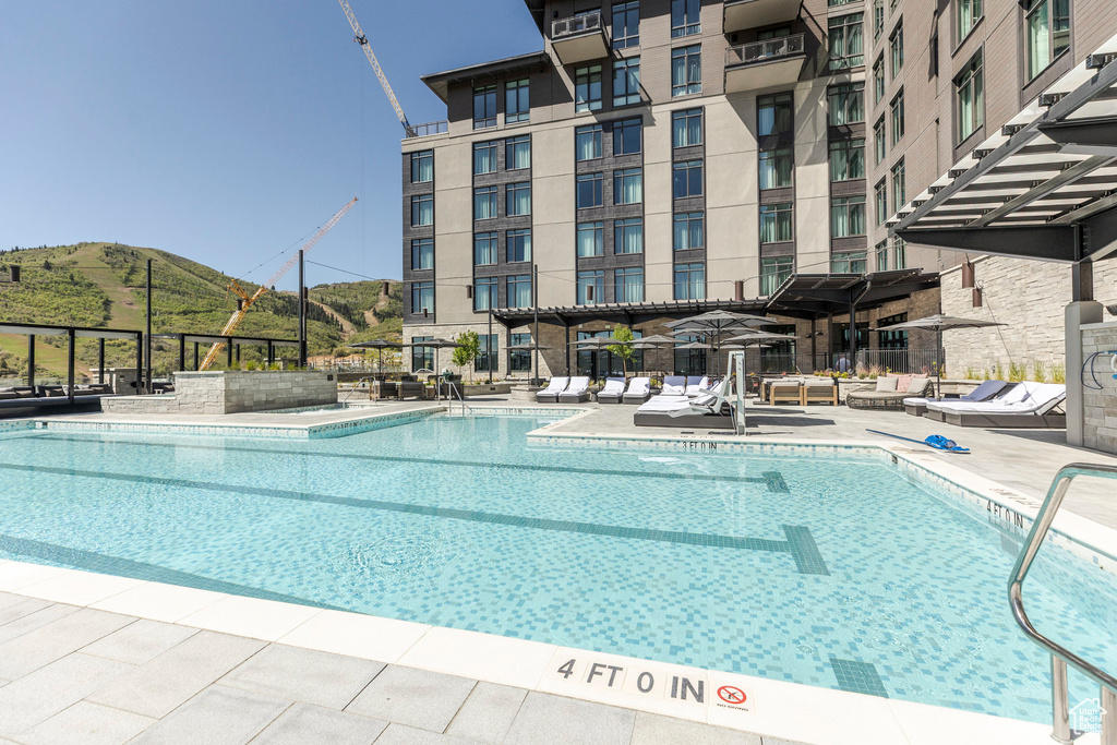 Community pool with a mountain view and a patio area