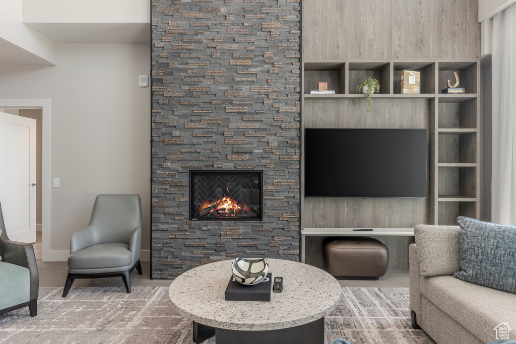 Living area with a stone fireplace and baseboards
