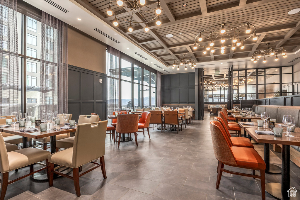 Dining area featuring visible vents, coffered ceiling, beam ceiling, wooden ceiling, and a decorative wall