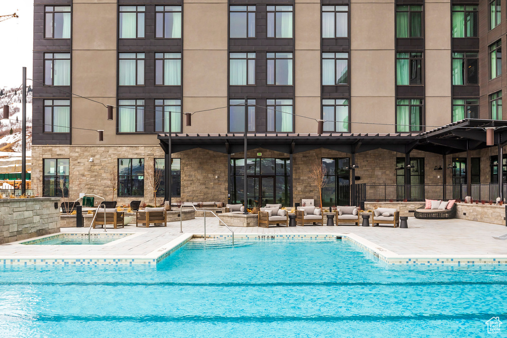 Community pool featuring outdoor lounge area, a community hot tub, and a patio area