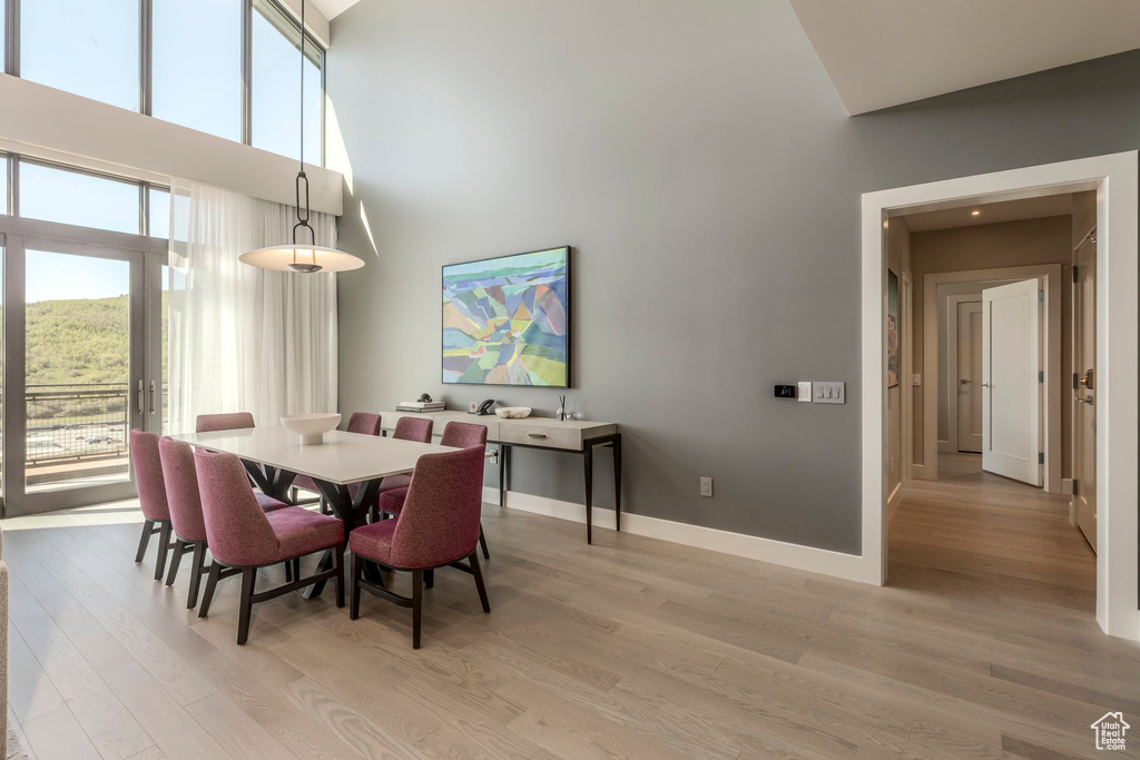 Dining space with a high ceiling, light wood finished floors, and baseboards