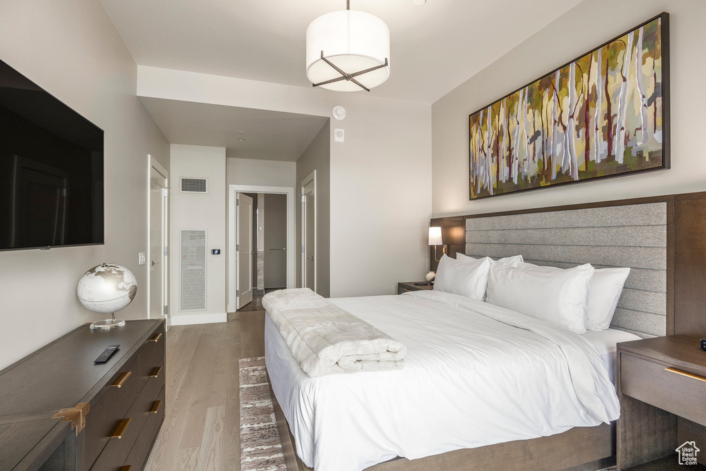 Bedroom with visible vents and wood finished floors