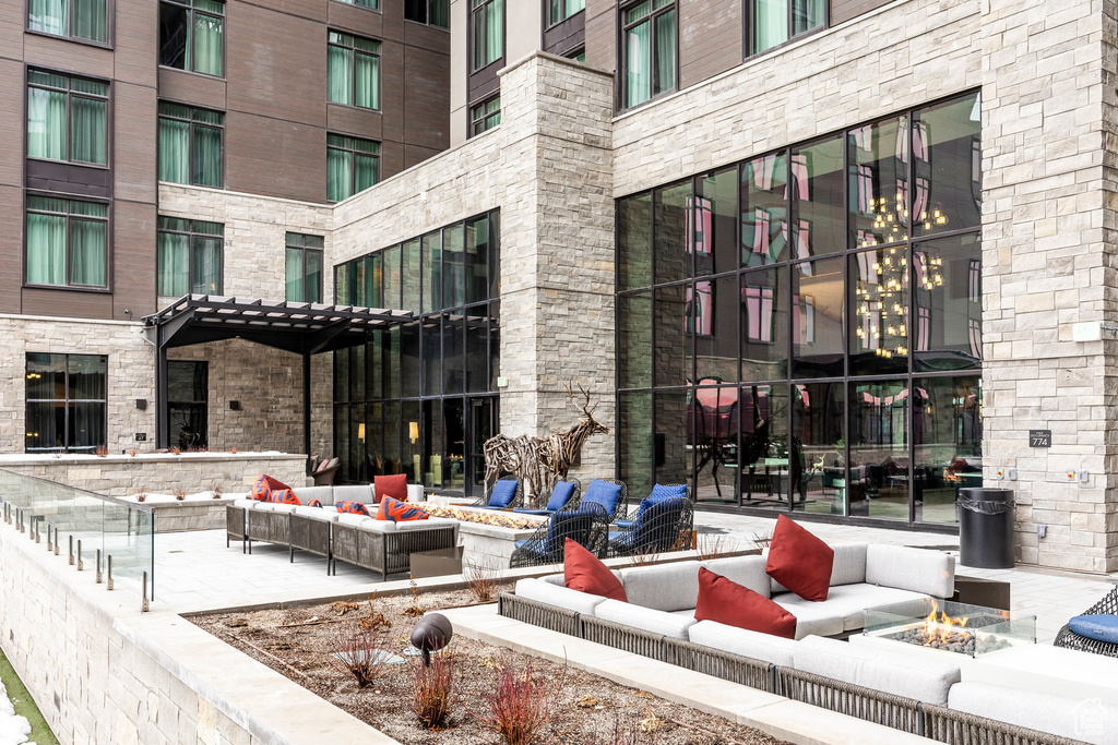 Surrounding community with an outdoor living space with a fire pit and a patio area