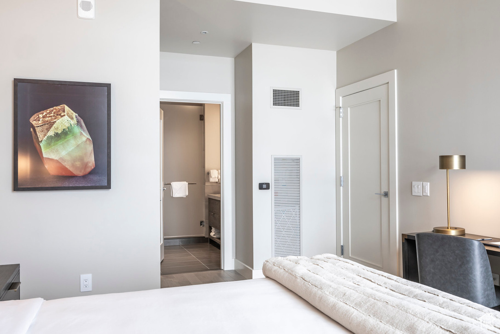 Bedroom with visible vents, baseboards, and ensuite bath