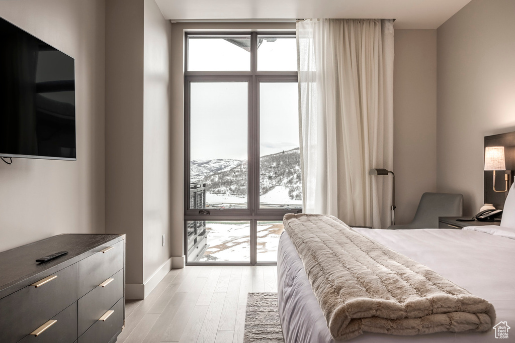 Bedroom featuring light wood-type flooring, baseboards, and a mountain view