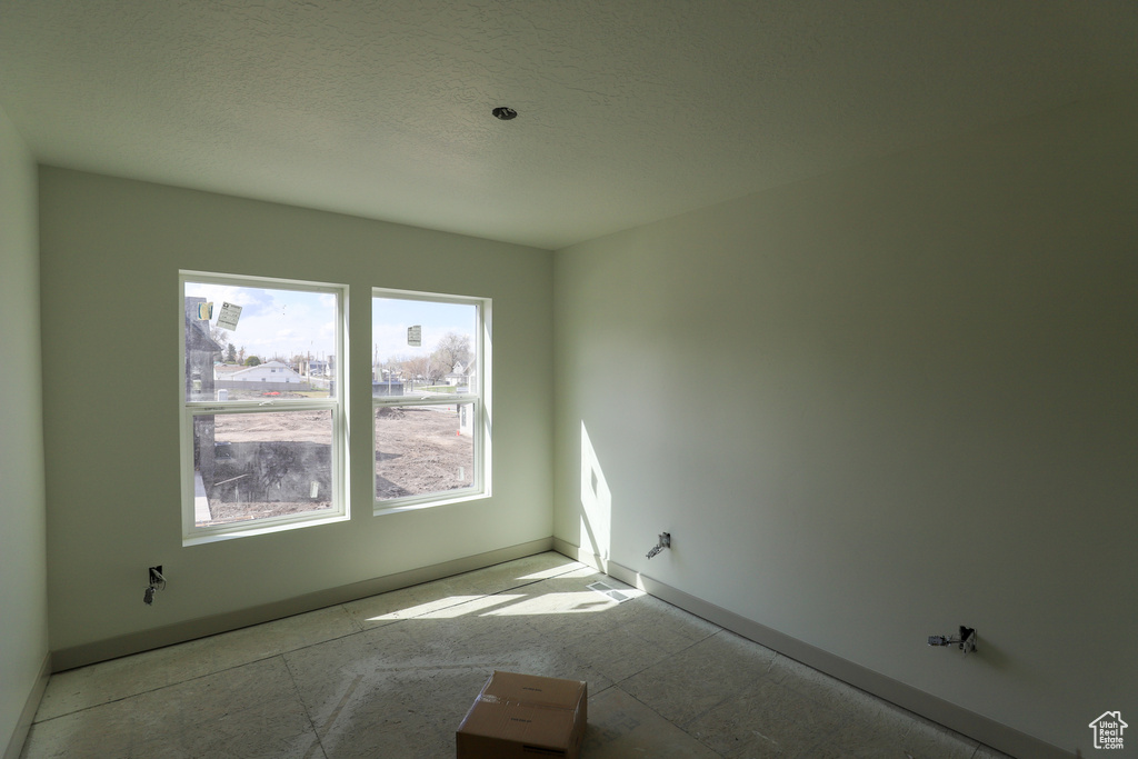 Spare room featuring baseboards and a textured ceiling