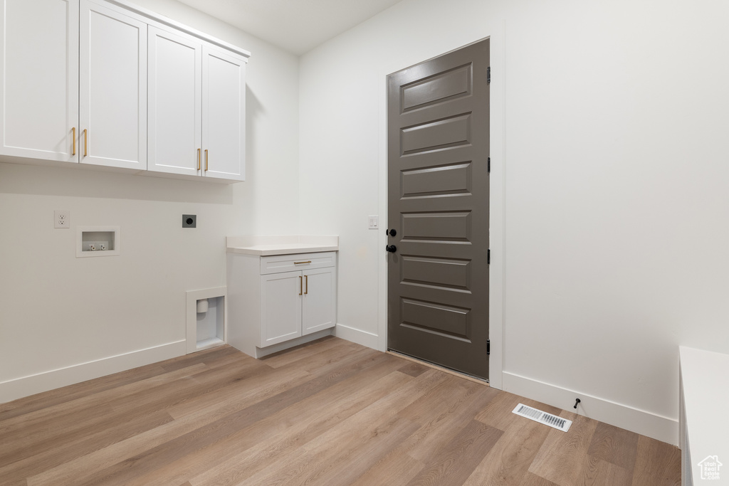 Washroom featuring baseboards, visible vents, light wood finished floors, cabinet space, and electric dryer hookup