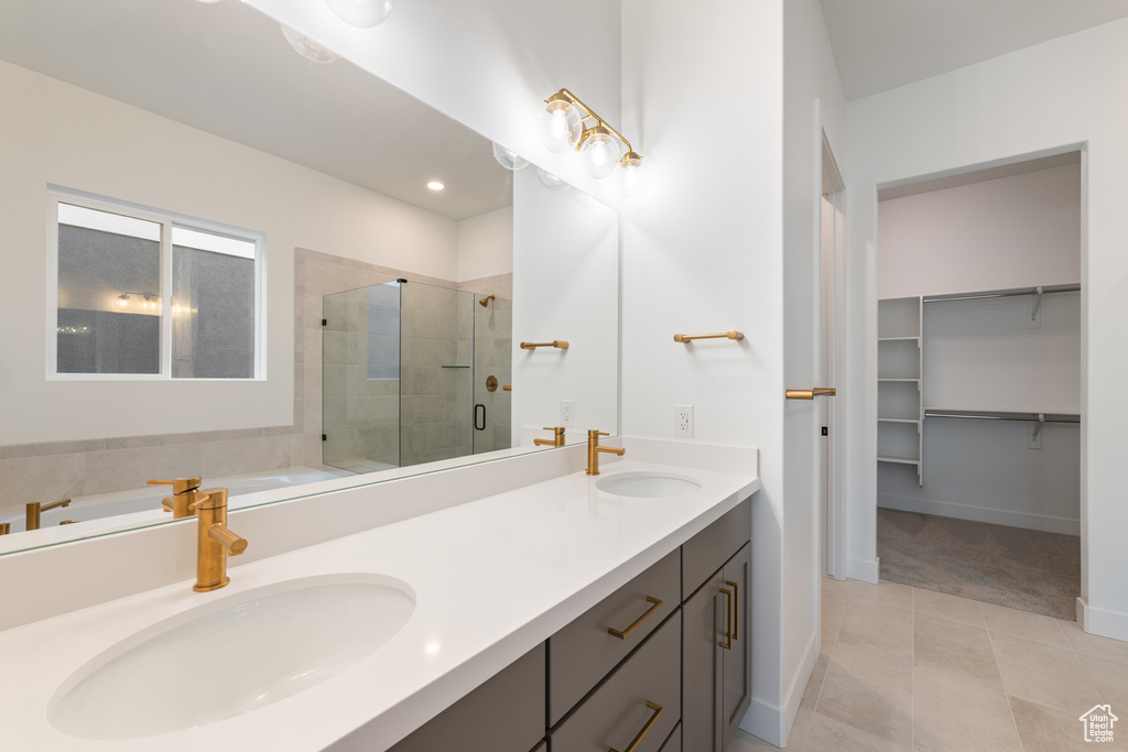 Bathroom with a shower stall, a garden tub, double vanity, and a sink
