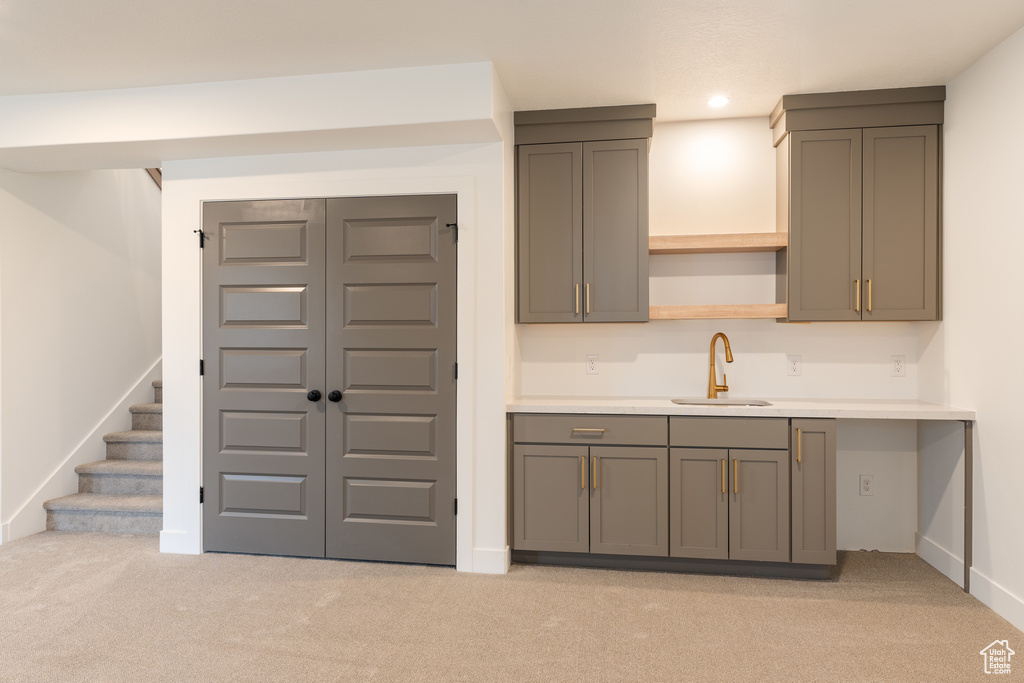 Kitchen with a sink, light colored carpet, light countertops, recessed lighting, and open shelves