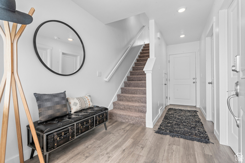 Foyer featuring recessed lighting, stairs, baseboards, and wood finished floors