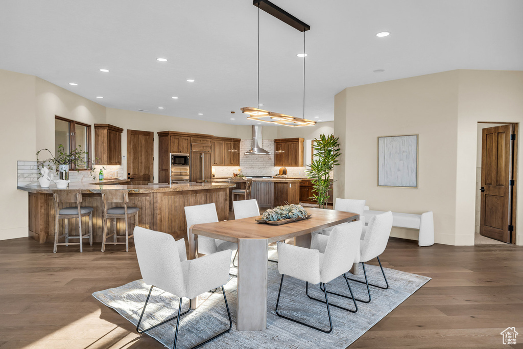 Dining room with recessed lighting, wood finished floors, and baseboards