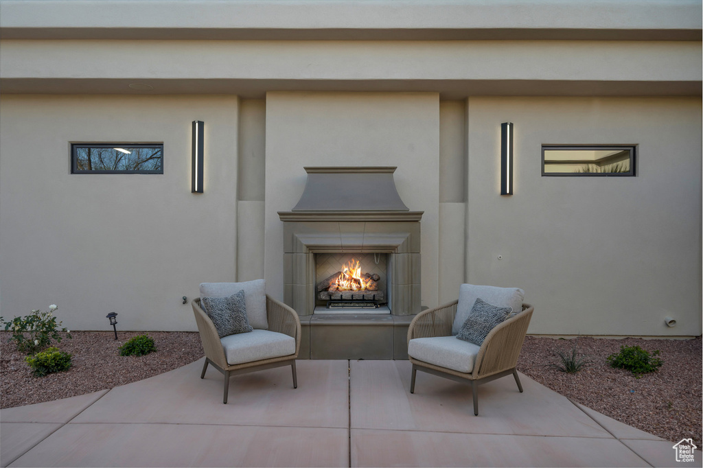 Sitting room featuring tile patterned flooring, carpet flooring, and a lit fireplace